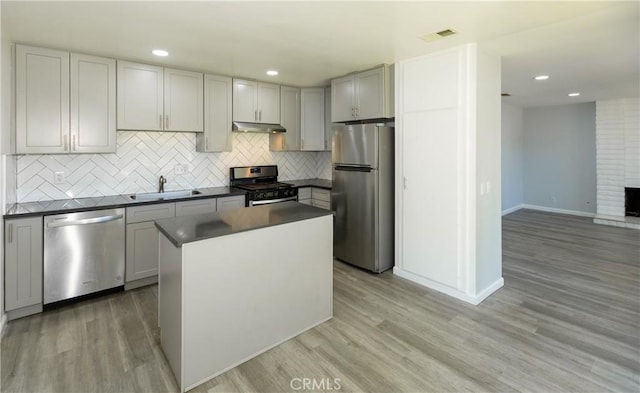 1841 Fisher Dr Unit B, Oxnard, CA 93035 - kitchen with appliances with stainless steel finishes, dark countertops, under cabinet range hood, backsplash, and recessed lighting