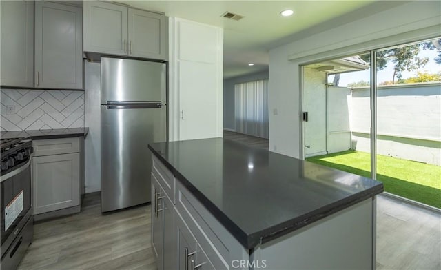 1841 Fisher Dr Unit B, Oxnard, CA 93035 - kitchen featuring freestanding refrigerator, dark countertops, decorative backsplash, light wood-type flooring, and range with gas stovetop