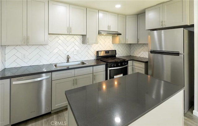 1841 Fisher Dr Unit B, Oxnard, CA 93035 - kitchen featuring appliances with stainless steel finishes, dark countertops, under cabinet range hood, and tasteful backsplash