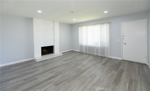 1841 Fisher Dr Unit B, Oxnard, CA 93035 - unfurnished living room with recessed lighting, a brick fireplace, and wood finished floors