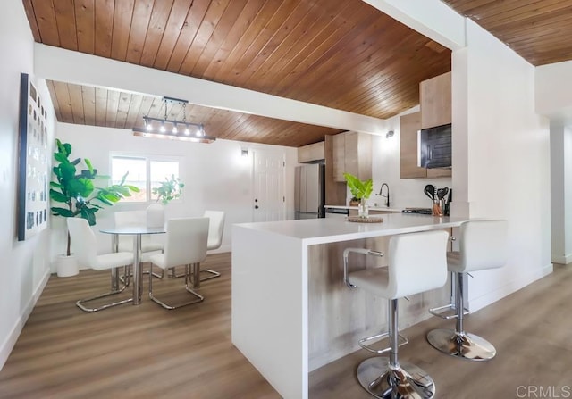 9753 Ivanho St, Spring Valley, CA 91977 - kitchen featuring wood ceiling, light countertops, light wood-type flooring, freestanding refrigerator, and a kitchen breakfast bar