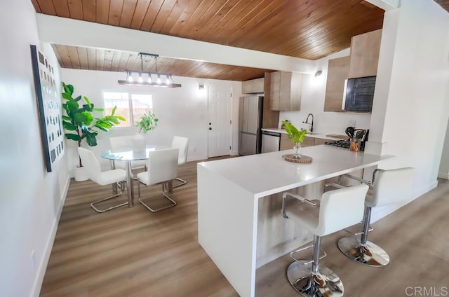 9753 Ivanho St, Spring Valley, CA 91977 - kitchen with a wood ceiling with exposed beams, light countertops, light wood-style floors, a peninsula, and a kitchen bar