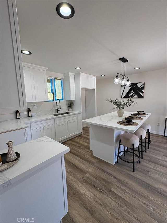 1526 W 54th St, Los Angeles, CA 90062 - kitchen with white cabinetry, dark wood-type flooring, decorative light fixtures, recessed lighting, and a breakfast bar area