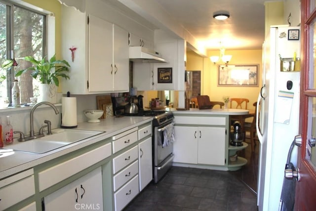 31705 Silver Spruce Dr, Running Springs, CA 92382 - kitchen featuring stainless steel gas range oven, freestanding refrigerator, under cabinet range hood, light countertops, and white cabinets