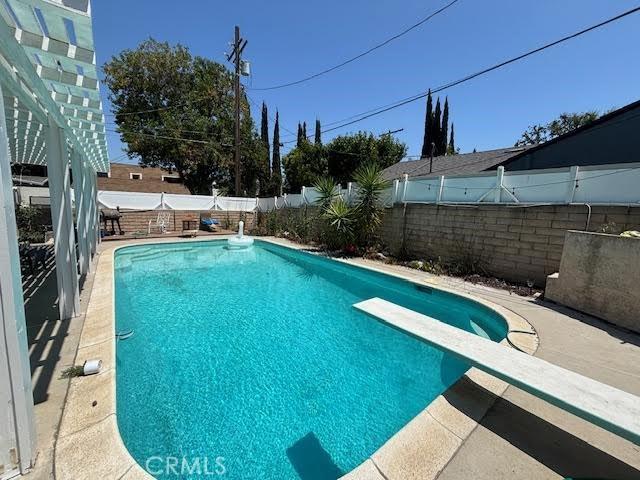 13600 Sylvan St, Valley Glen, CA 91401 - view of pool with a diving board, a fenced backyard, and a patio