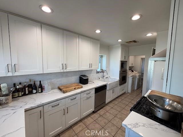 13600 Sylvan St, Valley Glen, CA 91401 - kitchen with stainless steel appliances, white cabinetry, light tile patterned floors, recessed lighting, and light stone countertops