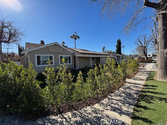 13600 Sylvan St, Valley Glen, CA 91401 - view of property exterior with solar panels and a chimney