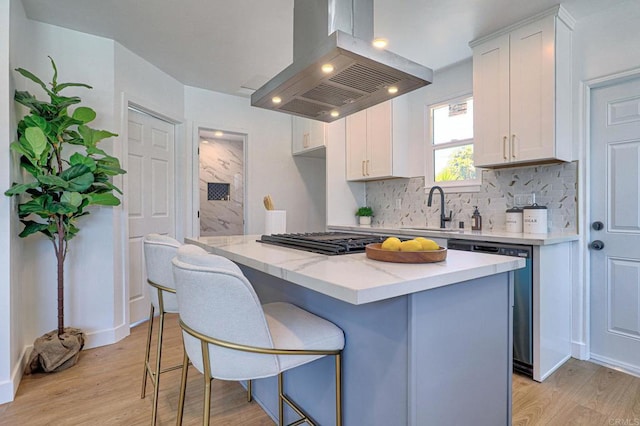 4711 Landis St, San Diego, CA 92105 - kitchen with island exhaust hood, dishwasher, decorative backsplash, light wood-style flooring, and recessed lighting