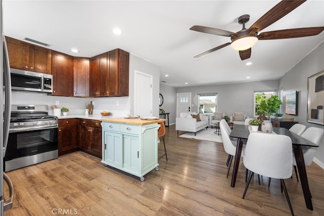 4513 E Cervato St, Long Beach, CA 90815 - kitchen with appliances with stainless steel finishes, open floor plan, light countertops, a ceiling fan, and light wood finished floors