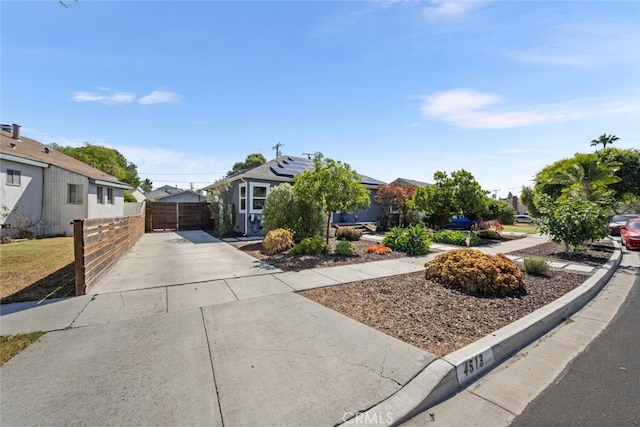 4513 E Cervato St, Long Beach, CA 90815 - view of property hidden behind natural elements featuring solar panels, concrete driveway, and a gate