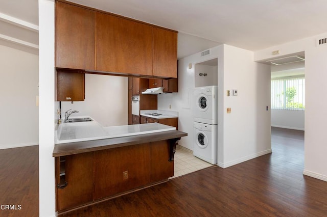 777 E Valley Blvd Unit 142, Alhambra, CA 91801 - kitchen with stacked washer and clothes dryer, white appliances, brown cabinets, wood finished floors, and under cabinet range hood