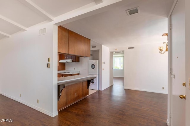 777 E Valley Blvd Unit 142, Alhambra, CA 91801 - kitchen featuring stacked washer / dryer, brown cabinets, dark wood-style flooring, a peninsula, and under cabinet range hood