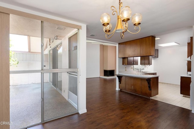 777 E Valley Blvd Unit 142, Alhambra, CA 91801 - kitchen featuring dark wood-style flooring, a chandelier, light countertops, a peninsula, and a breakfast bar