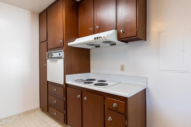 777 E Valley Blvd Unit 142, Alhambra, CA 91801 - kitchen featuring under cabinet range hood, white appliances, light countertops, light tile patterned flooring, and brown cabinetry