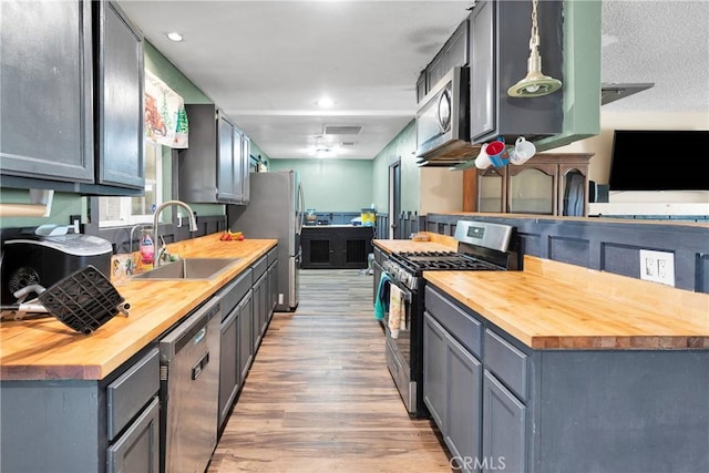 13144 Algonquin Rd, Apple Valley, CA 92308 - kitchen featuring wooden counters, appliances with stainless steel finishes, light wood-style flooring, and recessed lighting