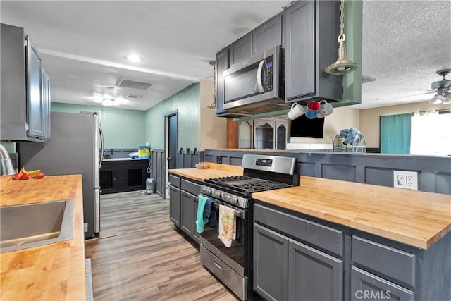 13144 Algonquin Rd, Apple Valley, CA 92308 - kitchen with wood counters, appliances with stainless steel finishes, gray cabinets, and light wood-style floors