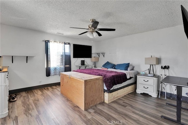 13144 Algonquin Rd, Apple Valley, CA 92308 - bedroom featuring dark wood-style flooring, a textured ceiling, and a ceiling fan
