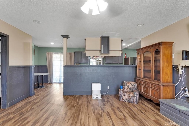 13144 Algonquin Rd, Apple Valley, CA 92308 - living area featuring a textured ceiling, wood finished floors, and wainscoting