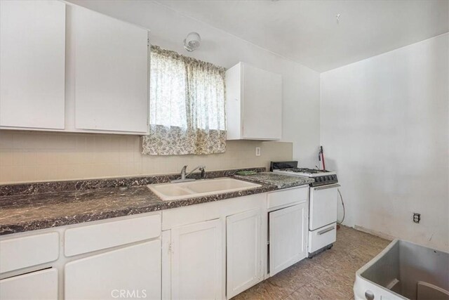 60810 Sunrise Rd, Whitewater, CA 92282 - kitchen with white range with gas cooktop, white cabinets, and decorative backsplash