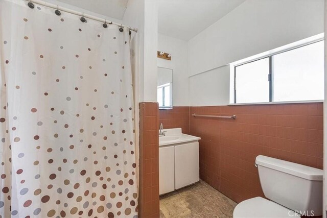 60810 Sunrise Rd, Whitewater, CA 92282 - bathroom with vanity, a shower with shower curtain, tile walls, and a wainscoted wall