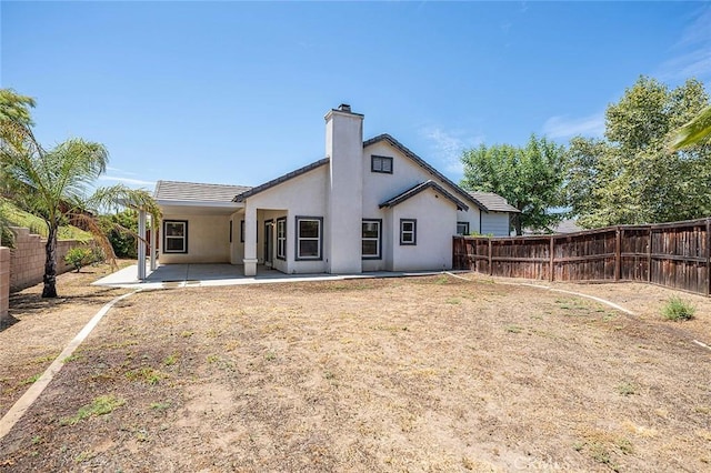 12038 Diego Ct, Moreno Valley, CA 92557 - back of property with a patio area, a fenced backyard, a chimney, and stucco siding