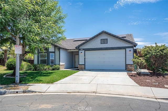 12038 Diego Ct, Moreno Valley, CA 92557 - view of front of property with a front lawn, an attached garage, concrete driveway, roof mounted solar panels, and stone siding