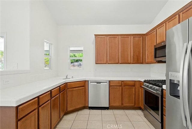 12038 Diego Ct, Moreno Valley, CA 92557 - kitchen featuring stainless steel appliances, light tile patterned flooring, and brown cabinets