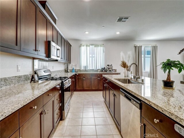 11576 S Crescent St, Desert Hot Springs, CA 92240 - kitchen with appliances with stainless steel finishes, light stone countertops, light tile patterned floors, recessed lighting, and dark brown cabinets