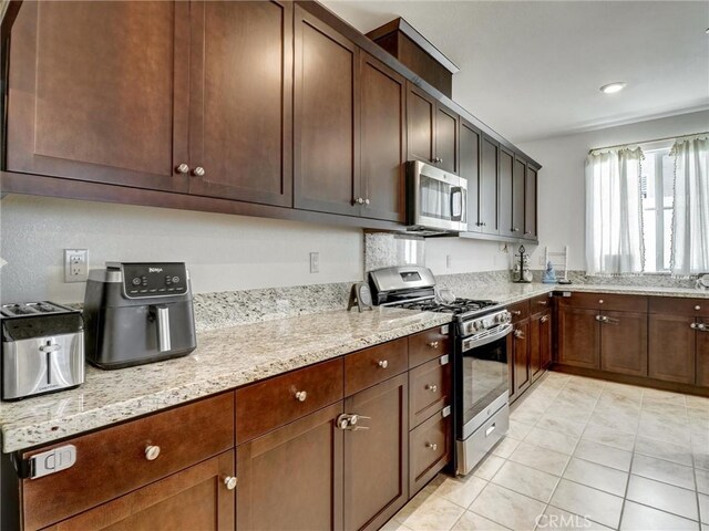 11576 S Crescent St, Desert Hot Springs, CA 92240 - kitchen with stainless steel appliances, light stone countertops, and light tile patterned floors
