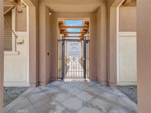 11576 S Crescent St, Desert Hot Springs, CA 92240 - doorway to property featuring a gate, stucco siding, and a security system
