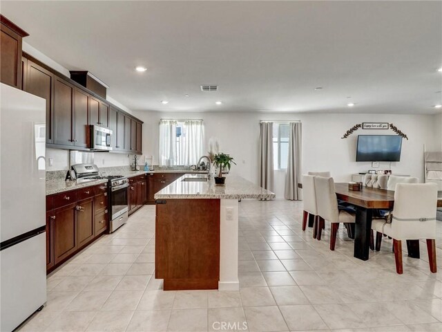 11576 S Crescent St, Desert Hot Springs, CA 92240 - kitchen with appliances with stainless steel finishes, recessed lighting, light stone counters, light tile patterned floors, and dark brown cabinets