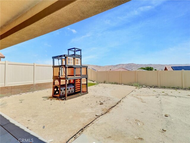 11576 S Crescent St, Desert Hot Springs, CA 92240 - view of jungle gym with a fenced backyard and a mountain view