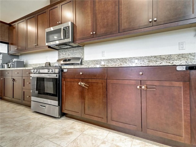 11576 S Crescent St, Desert Hot Springs, CA 92240 - kitchen featuring stainless steel appliances, light tile patterned flooring, light stone counters, and dark brown cabinetry