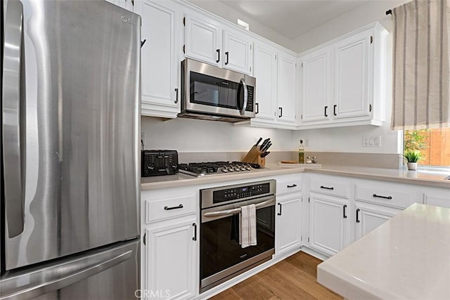 35 Colony Way, Aliso Viejo, CA 92656 - kitchen with stainless steel appliances, light wood-style flooring, light countertops, and white cabinetry