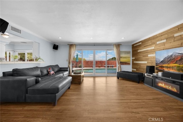 1935 Adobe Ave, Corona, CA 92882 - living room featuring wooden walls, ornamental molding, wood finished floors, healthy amount of natural light, and a glass covered fireplace