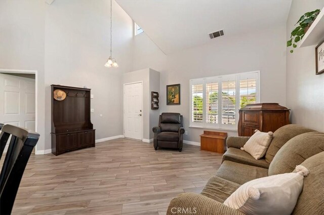 27242 Cabrillo Dr, Menifee, CA 92586 - living room with high vaulted ceiling, light wood finished floors, and a chandelier