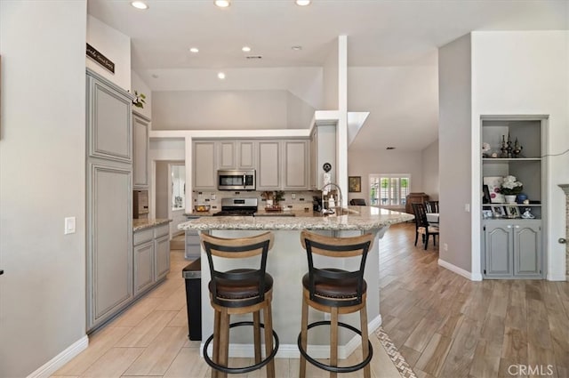 27242 Cabrillo Dr, Menifee, CA 92586 - kitchen featuring gray cabinetry, appliances with stainless steel finishes, a peninsula, decorative backsplash, and recessed lighting
