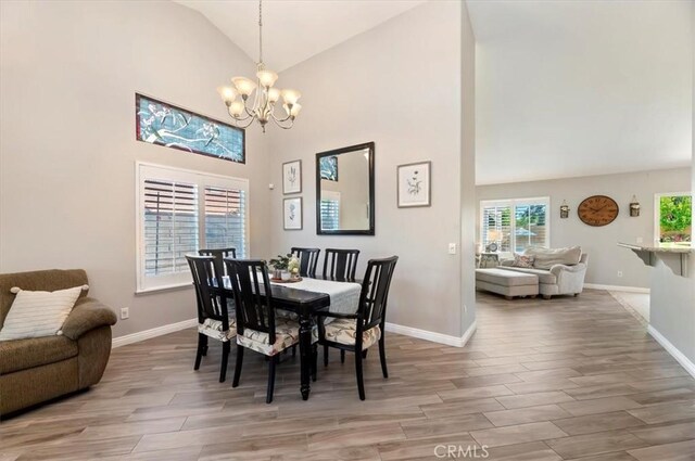 27242 Cabrillo Dr, Menifee, CA 92586 - dining area featuring a chandelier, light wood finished floors, and high vaulted ceiling