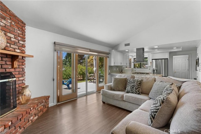 181 Eucalyptus Rd, Nipomo, CA 93444 - living room with a brick fireplace, dark wood finished floors, and vaulted ceiling