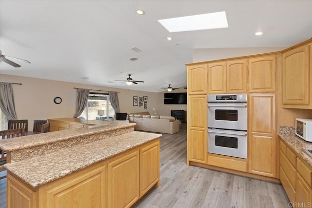 28880 Mac Tan Rd, Valley Center, CA 92082 - kitchen with stainless steel double oven, light brown cabinets, a ceiling fan, white microwave, and a skylight