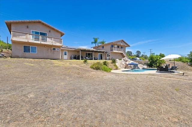 28880 Mac Tan Rd, Valley Center, CA 92082 - rear view of house with stucco siding, an outdoor pool, and a balcony