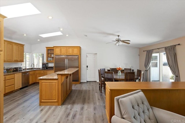 28880 Mac Tan Rd, Valley Center, CA 92082 - kitchen featuring appliances with stainless steel finishes, a skylight, lofted ceiling, glass insert cabinets, and light wood-style flooring