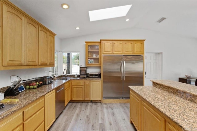 28880 Mac Tan Rd, Valley Center, CA 92082 - kitchen featuring stainless steel appliances, a skylight, vaulted ceiling, light stone countertops, and light wood-type flooring