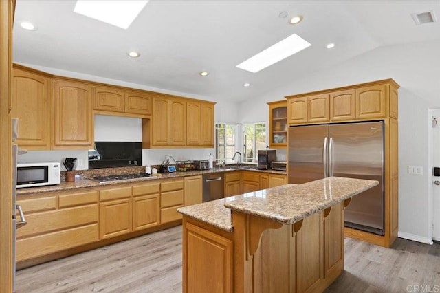 28880 Mac Tan Rd, Valley Center, CA 92082 - kitchen featuring stainless steel appliances, a skylight, vaulted ceiling, light stone counters, and light wood-type flooring