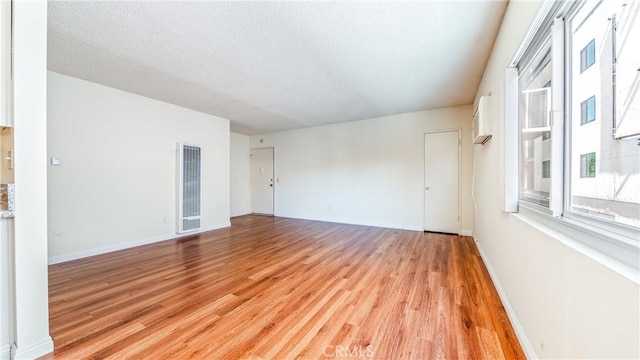 6045 Hazelhurst Pl, North Hollywood, CA 91606 - empty room featuring a heating unit, light wood-style floors, and a textured ceiling