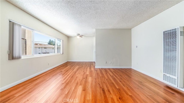 6045 Hazelhurst Pl, North Hollywood, CA 91606 - empty room with a heating unit, a textured ceiling, light wood-style floors, and a ceiling fan
