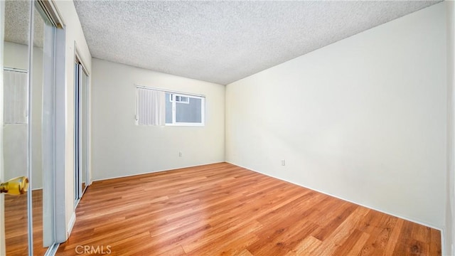 6045 Hazelhurst Pl, North Hollywood, CA 91606 - unfurnished bedroom featuring light wood-style floors, a textured ceiling, and a closet