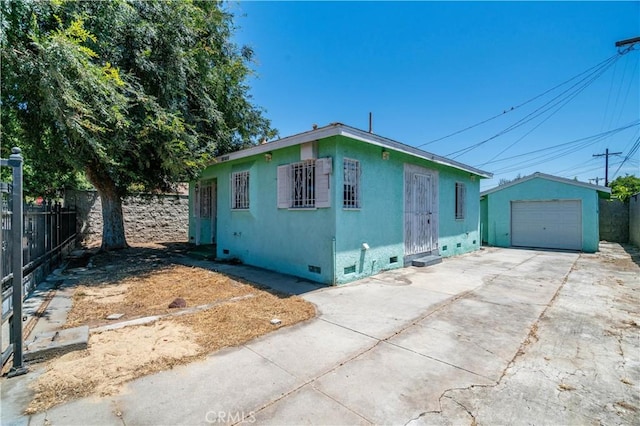 11860 Athens Way, Los Angeles, CA 90061 - view of front facade featuring concrete driveway, a garage, crawl space, an outdoor structure, and stucco siding