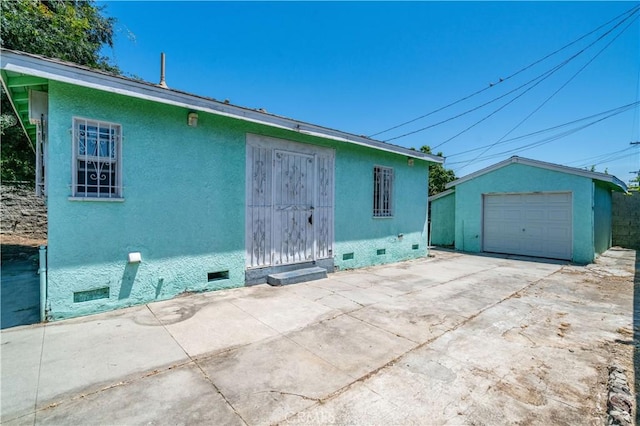 11860 Athens Way, Los Angeles, CA 90061 - back of house with crawl space, concrete driveway, a detached garage, an outdoor structure, and stucco siding