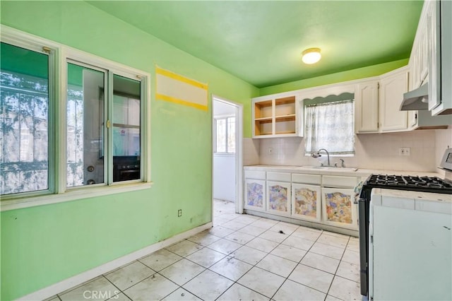 11860 Athens Way, Los Angeles, CA 90061 - kitchen with gas stove, light countertops, white cabinets, decorative backsplash, and under cabinet range hood